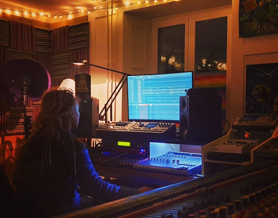 No fixed roles. Olivia producing at the workstation during a late-night studio session, surrounded by synths, lights and the unmistakable TEAC console.